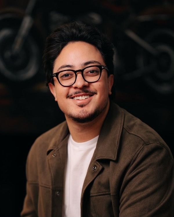 Retrato de Pedro Barros sorrindo, de óculos